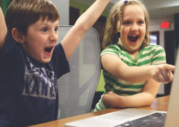 two-kids-cheering-at-computer-gaming